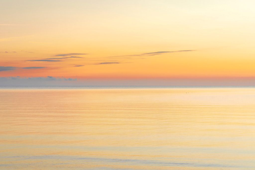 Wandbild: Morgenrot am Strand in Kronsgaard | Sanfte Farben und eine beruhigende Küstenlandschaft – dieses Wandbild schafft eine entspannte und gelassene Atmosphäre. Der warme Orangeton des Himmels und die sanfte Reflexion des Sonnenlichts auf dem Meer fördern das Wohlbefinden und tragen zur stressfreien Gestaltung medizinischer Räume bei. Perfekt für Wartezimmer, Behandlungsräume oder Empfangsbereiche, um eine harmonische Umgebung zu schaffen, die Ruhe und Gelassenheit ausstrahlt. - Realisiert mit Pictrs.com