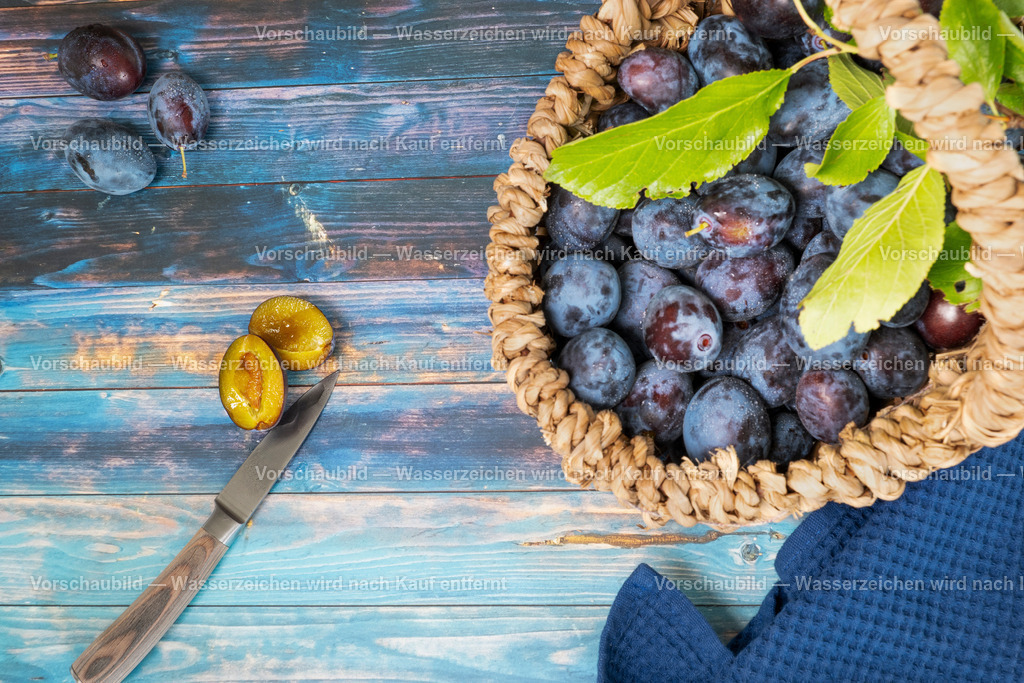 Ein Korb frisch geerntete Pflaumen werden verarbeitet  | Ein Korb frisch geerntete Pflaumen werden verarbeitet. Eine Pflaume aufgescghnitten - Realisiert mit Pictrs.com