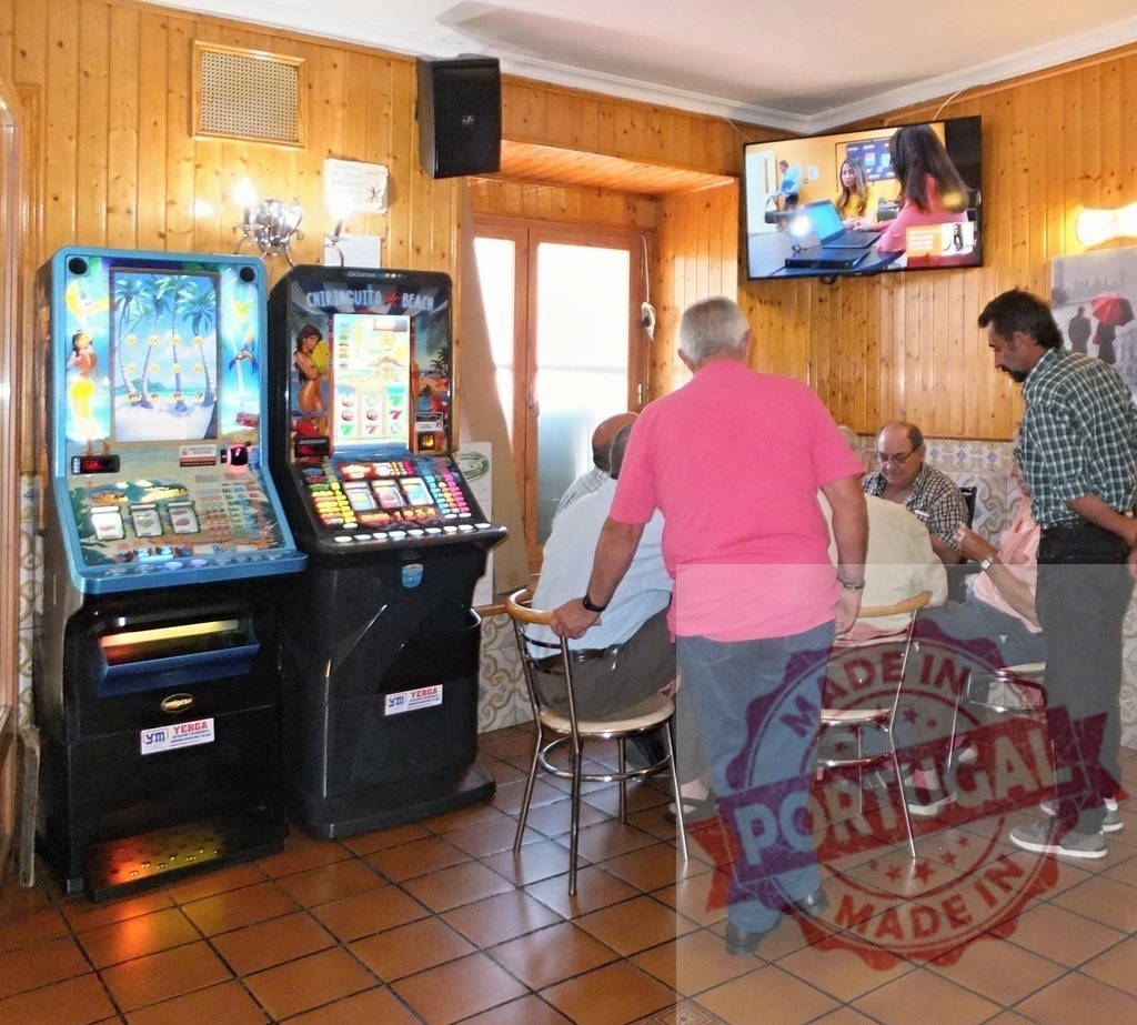 Men socialising in bar with slot machines | Various men gathering, socialising and gambling in a bar with wooden walls - Realisiert mit Pictrs.com
