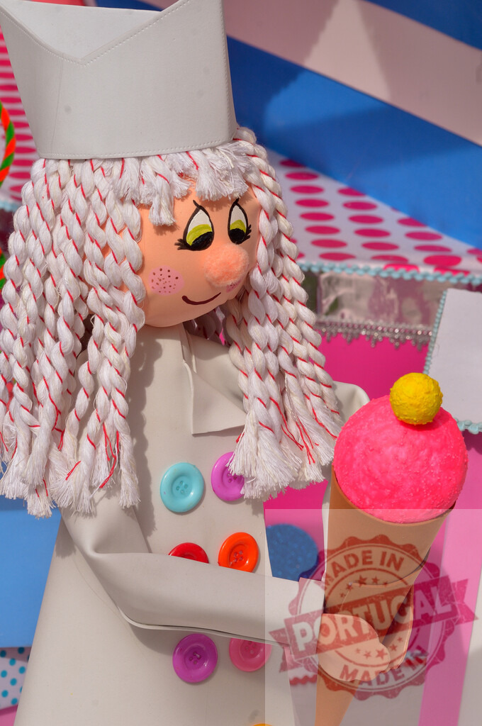 Chef doll holding colorful ice cream cone. Fallas Fiestas Communidad Valenciana | Whimsical chef doll toy with braided hair and button details holding a large pink ice cream - Realisiert mit Pictrs.com