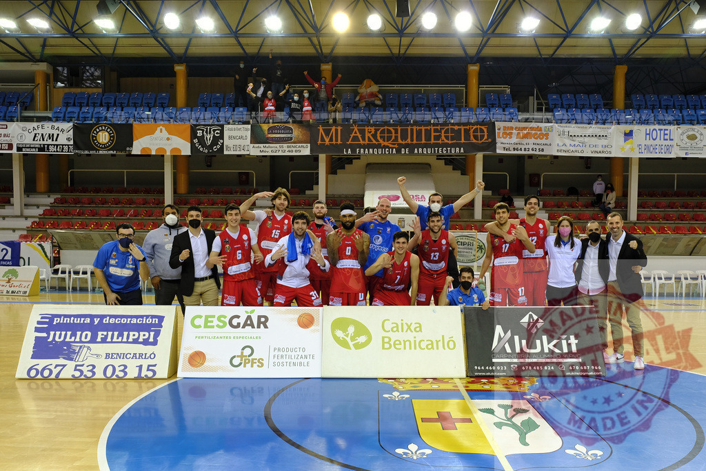 Basketball team players celebrating victory in Benicarló arena | Basketball team players celebrating victory during a game in a sport arena with sponsor advertisements - Realized with Pictrs.com