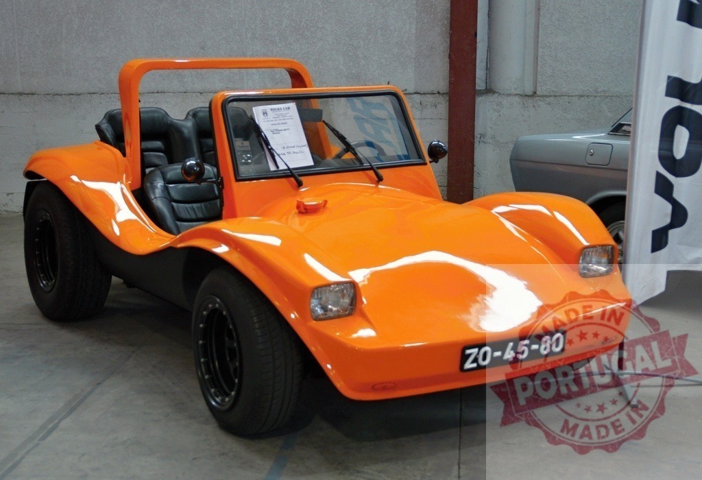 Shiny orange beach buggy parked indoors | Small orange and black buggy parked on concrete floor in an exhibition space - Realized with Pictrs.com