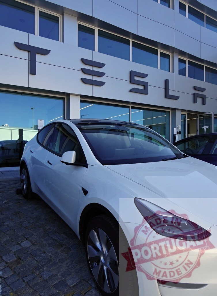White Tesla Model Y electric vehicle at Tesla dealership | White Tesla Model Y electric car parked outside a modern Tesla showroom - Realisiert mit Pictrs.com