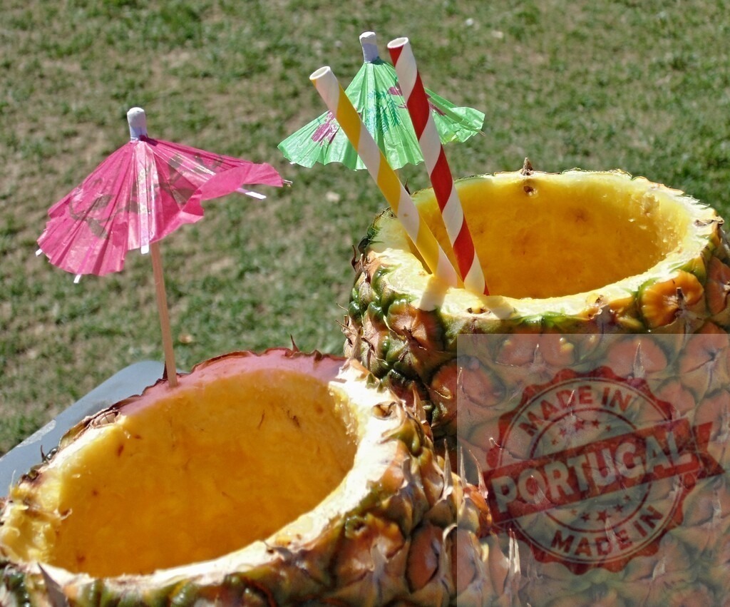 Pineapple tropical drinks ready for summer party fun | Pineapple cocktails with colorful straws and umbrellas on a sunny day - Realisiert mit Pictrs.com