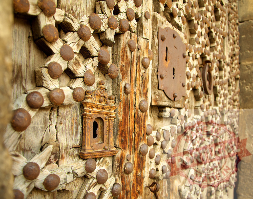 Intricate Wooden Door with Ornate Metal Accents | Detailed view of a rustic wooden door featuring decorative metal elements - Realized with Pictrs.com