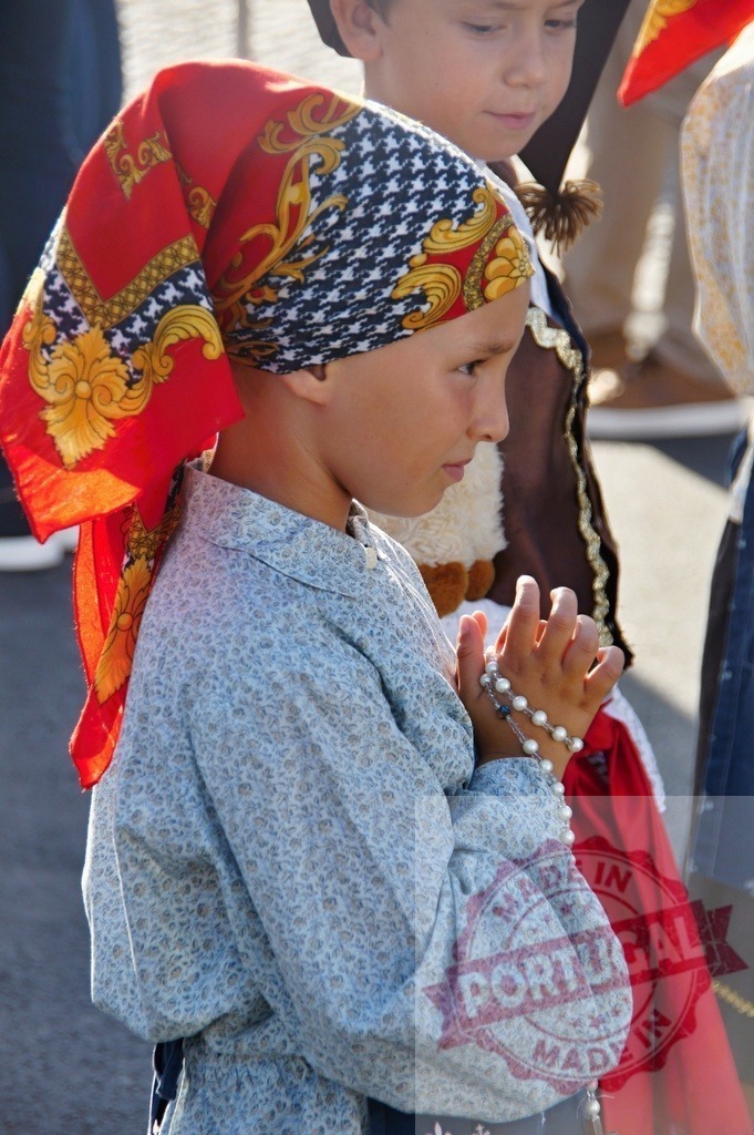 Young girl wearing traditional costume praying with rosary beads | Procession 15.08.2025 - Assumption Day - Paco de Sousa, Portugal Young girl wearing traditional folk costume is praying with rosary beads in her hands - Realisiert mit Pictrs.com