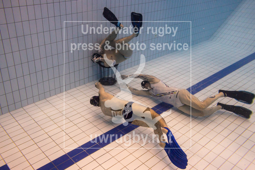 TC Bamberg vs. TSV Malsch, Unterwasser-Rugby, 1. Bundesliga Süd, 5. Spieltag, 2024/2025, 23.03.2025 | TC Bamberg (weiß) vs. TSV Malsch, (blau). Martin Schottmüller (TSV Malsch, #01) beim Konter auf  das Bamberger Tor an, Michael Nosseir (TC Bamberg, #14) schwimmt parallel zu ihm, während der Torwart Sebastian Lange (TC Bamberg, #11) das Tor dicht hält. - Realisiert mit Pictrs.com