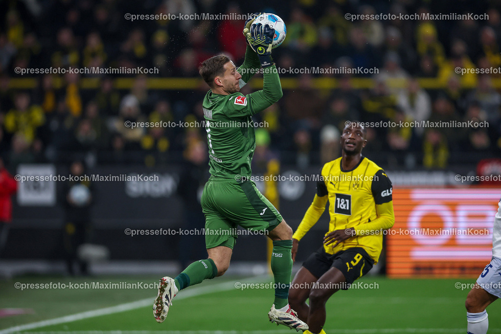 BVB15122402191 | 15.12.2024, Fußball, Borussia Dortmund - TSG 1899 Hoffenheim, 1. Fußball Bundesliga, 14. Spieltag, Signal Iduna Park, Saison 2024 2025: Torwart Oliver Baumann (Hoffenheim #1) verteidigt gegen Serhou Guirassy (BVB #9)DFB regulations prohibit any use of photographs as image sequences and or quasi-video.