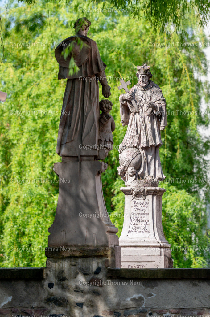 Mittelbruecke-Bensheim-2-Fotografie-Thomas-Neu | bbe, Bensheim, Die unter Denkmalschutz stehende Mittelbrücke in Bensheim an der Bergstraße wurde 1732 über den Winkelbach errichtet. Die barocken Brückenheiligen prägen bis heute das Erscheinungsbild: Im Vordergrund ist der heilige Franz Xaver zu sehen, dem Betrachter den Rücken zugewandt, während auf der gegenüberliegenden Seite der heilige Johannes Nepomuk ivom frischen Grün dder Trauerweide  eingerahmt scheint.,Bild: THomas Neu