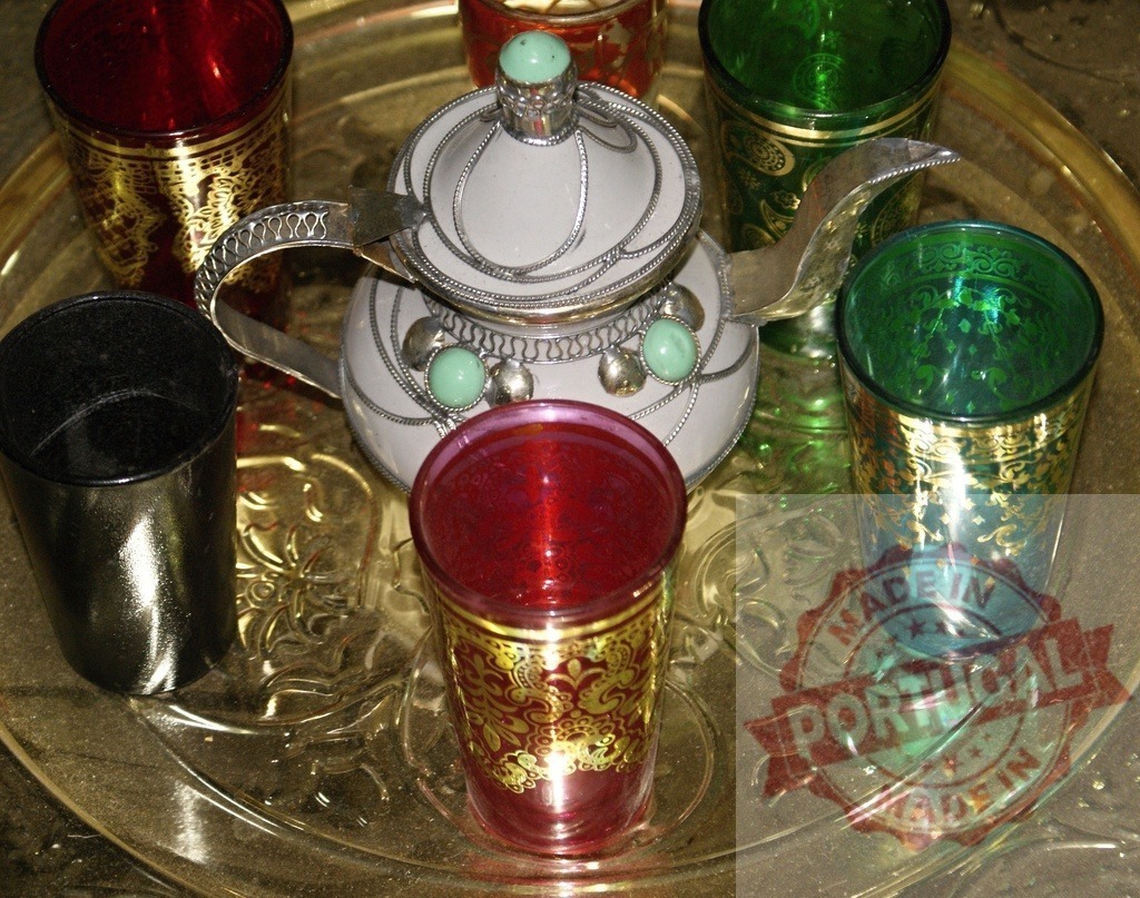 Moroccan tea set on traditional brass tray | Traditional Moroccan teapot and colorful glasses organized on ornate brass serving tray - Realized with Pictrs.com