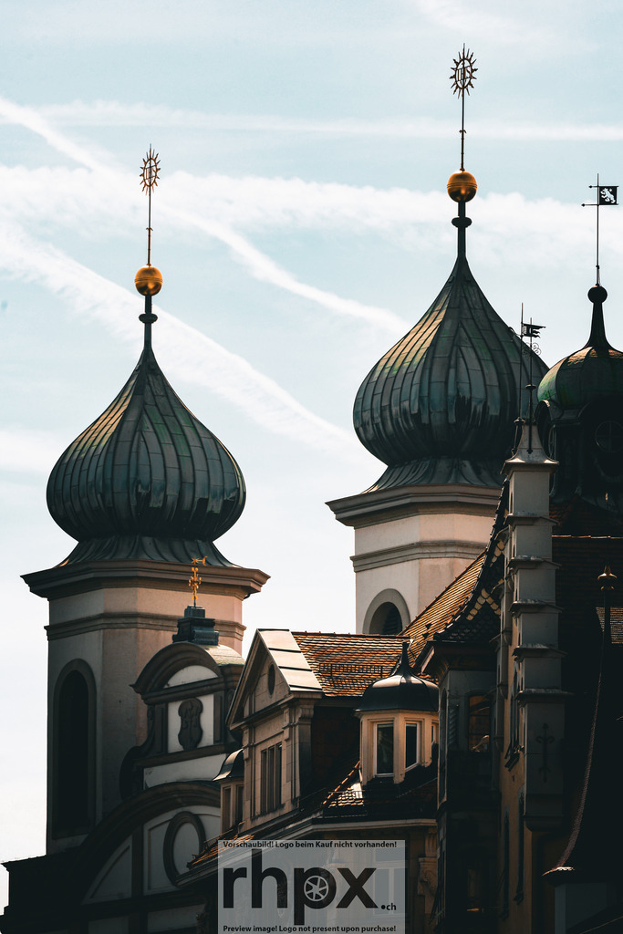 Jesuitenkirche Luzern – Türme im Abendlicht | Barock. Symmetrie. Himmelsgold.Die ikonischen Zwiebeltürme der Jesuitenkirche in Luzern erheben sich elegant in den Himmel. Die dunklen, gerippten Kuppeln kontrastieren mit den hellen Türmen und den filigranen, goldenen Turmspitzen. Ein beeindruckendes Zeugnis barocker Baukunst und religiöser Pracht, die sich in den historischen Dächern der Altstadt spiegelt.Wähle unter "Produktauswahl" dein Wunschformat: Vom klassischen Wandbild über Puzzle &amp; Tassen bis zum digitalen Download (z.B. als Handy-Hintergrund). - Realisiert mit Pictrs.com
