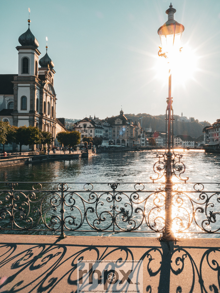 Sommerliches Luzern | Licht. Geschichte. Fluss.
Die warme Sommersonne taucht die Ufer der Reuss in ein goldenes Licht und lässt Luzern erstrahlen. Das Spiel von Licht und Schatten auf der Brücke fängt die friedliche Atmosphäre eines Nachmittags in der Leuchtenstadt perfekt ein.
Wähle unter "Produktauswahl" dein Wunschformat: Vom klassischen Wandbild über Puzzle &amp; Tassen bis zum digitalen Download (z.B. als Handy-Hintergrund).
 - Realisiert mit Pictrs.com
