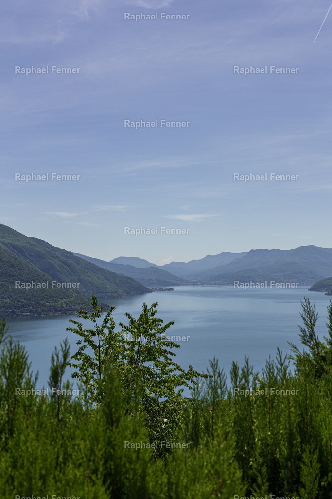 Blick auf den Lago Maggiore oberhalb von Brissago | Diese Aufnahme entstand oberhalb von Brissago und zeigt den Lago Maggiore in seiner ganzen Weite. Die grüne Vegetation im Vordergrund steht im Kontrast zur ruhigen Wasseroberfläche und den sanft ansteigenden Hügeln am Horizont. Ein friedlicher Moment in mediterraner Atmosphäre mit typischem Tessiner Flair.