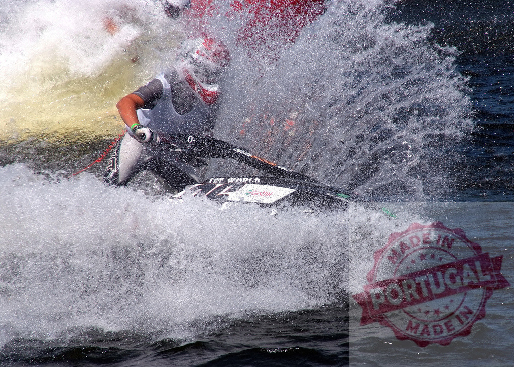 Pilot riding jet ski making big splash during competition | Professional pilot making big splash while riding jet ski during watercraft competition - Realisiert mit Pictrs.com