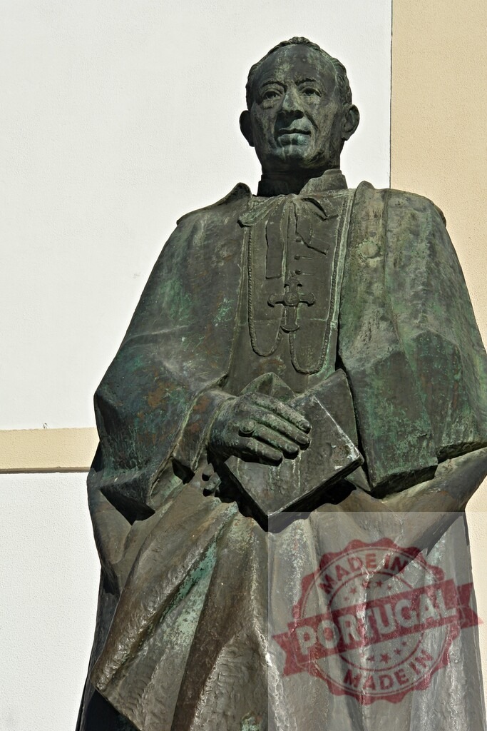 Bronze statue depicting religious cleric holding book | Weathered bronze sculpture presenting a cleric or priest in traditional robes holding a book - Realized with Pictrs.com