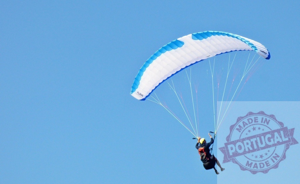 Paraglider flying in clear blue sky, enjoying freedom | Paraglider pilots a colorful canopy, soaring high against a bright blue sky - Realisiert mit Pictrs.com