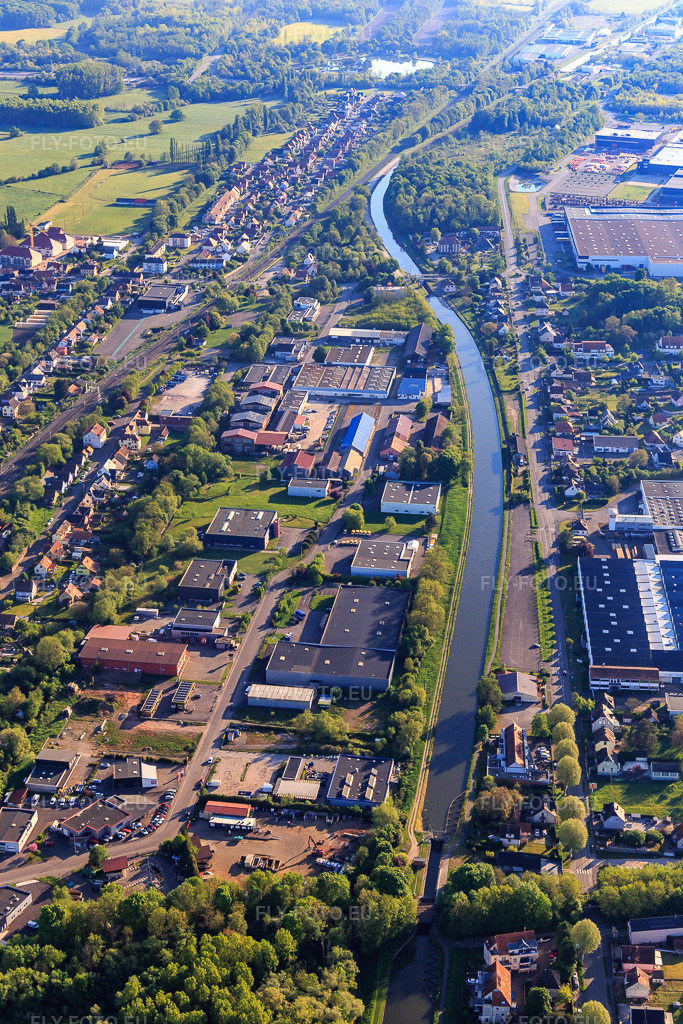 Vue aérienne: Tracé du canal de la Marne au Rhin (en allemand : Rhein-Marne-Kanal) dans la zone industrielle à Monswiller dans le département Bas Rhin, France. Photo: IMG_145978.jpg prise le 01/05/2025 par Werner Riehm/FLY-FOTO.eu – Résolution de l'original: 3648 x 5472 px