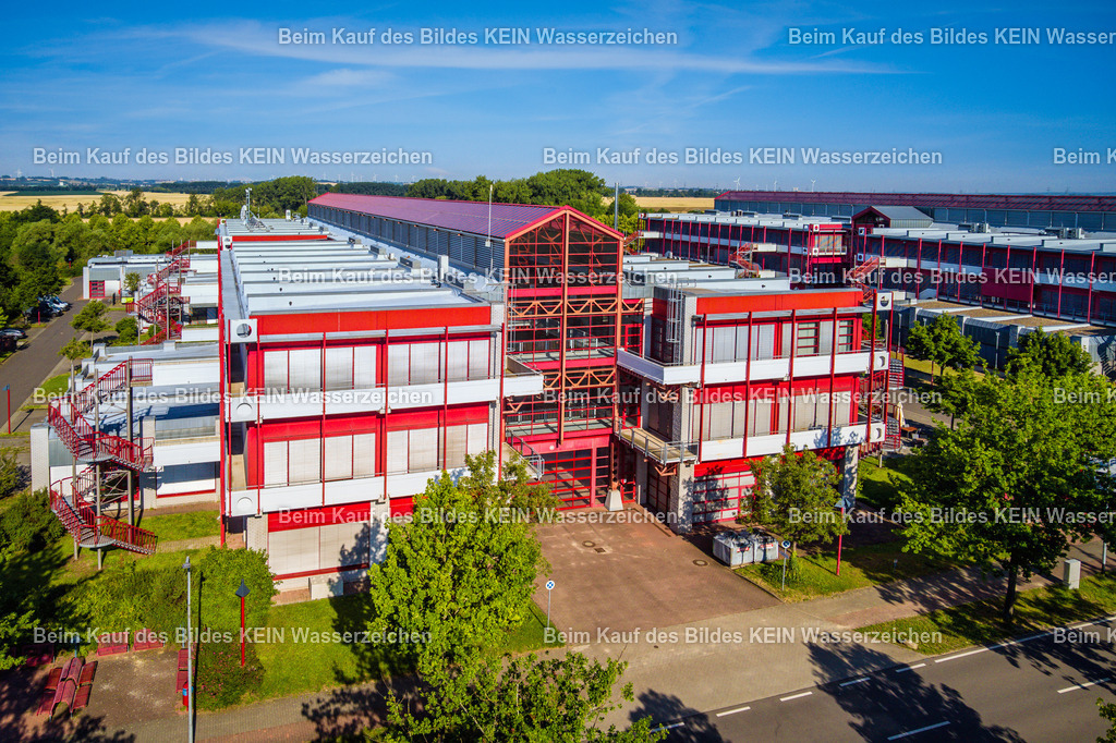 IGZ Barleben-0064 | Blick aus der tief fliegenden Drohne auf das markante rote Stahlgebäude des Innovations- und Gründerzentrums (IGZ) in Barleben. Die nahe Perspektive stellt die Architektur und die klare Konstruktion des Gebäudes in den Mittelpunkt.Die ungewöhnliche Farbgebung und die sichtbare Stahlstruktur verleihen dem Gebäude einen hohen Wiedererkennungswert. Durch die niedrige Drohnenperspektive entsteht ein deutlich anderer Eindruck als bei einer klassischen Standortaufnahme aus größerer Höhe.Das Motiv zeigt, wie sich auch einzelne Unternehmens- und Gewerbegebäude mit einer gezielt gewählten Perspektive prägnant darstellen lassen – nicht nur als Teil eines gesamten Gewerbestandortes, sondern als eigenständiges architektonisches Motiv. - Realisiert mit Pictrs.com