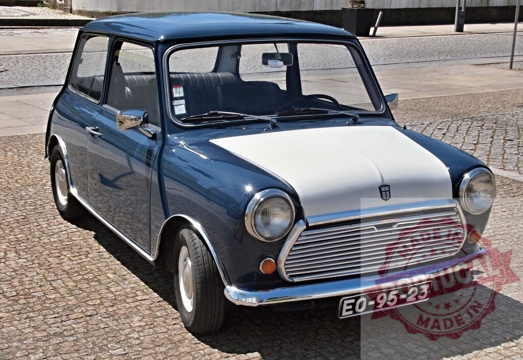 Blue and white classic Mini Cooper parked on cobblestone street | Classic Mini Cooper car parked on a traditional cobblestone street during daytime - Realisiert mit Pictrs.com