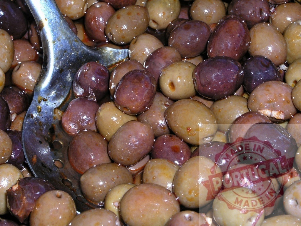 Mixed olives in oil with metal scoop | Mixed green and black olives soaking in oil, ready for serving - Realized with Pictrs.com