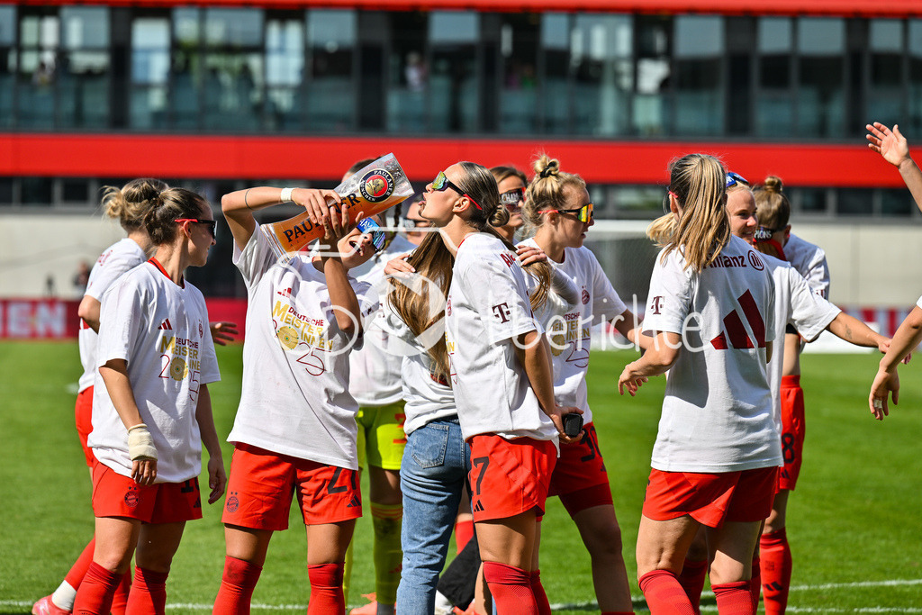 FC Bayern München - SC Freiburg | Die Spielerinnen des FC Bayern feiern die Meisterschaft nach dem Heimsieg gegen den SC Freiburg / Frauen Bundesliga: FC Bayern Muenchen - SC Freiburg, FC Bayern Campus am 27.04.2025 / Arianna CARUSO (FC Bayern Muenchen Frauen 27) gibt Klara BUEHL (FCB #17) einen Schluck auf dem Paulaner Bierkrug / Bierglas