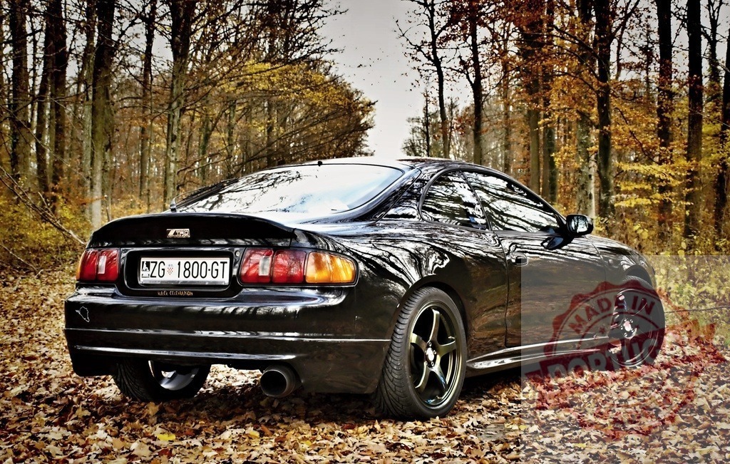 Black Toyota Celica GT parked in autumn forest | Tuned black Toyota Celica GT is parked in a beautiful autumn forest - Realized with Pictrs.com
