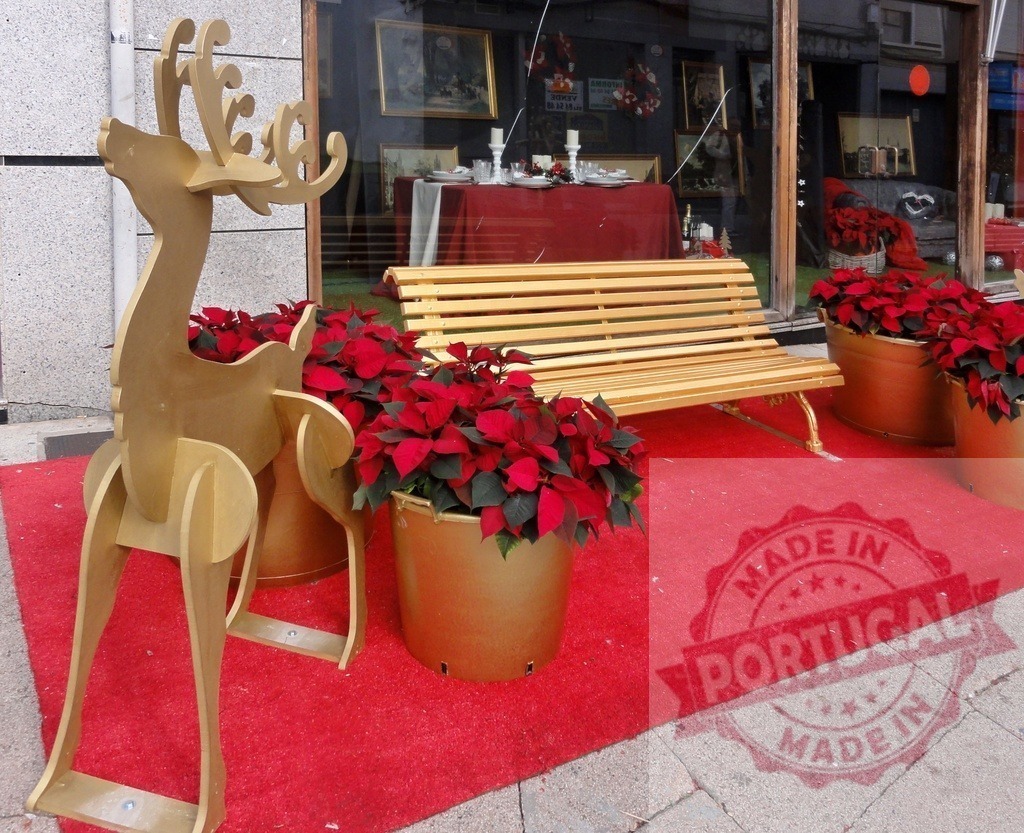 Golden reindeer and poinsettias decorating a shop entrance for Christmas | Christmas decorations featuring a golden reindeer and poinsettias in front of a shop - Realized with Pictrs.com