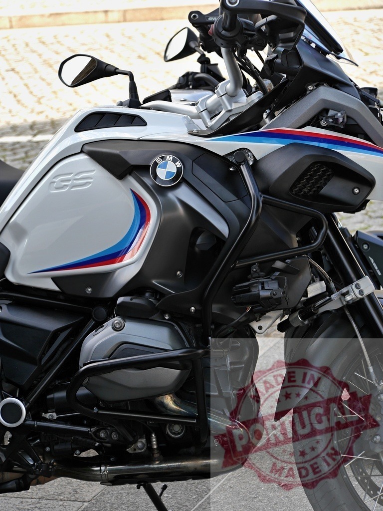 Close-up of BMW R 1250 GS Adventure motorcycle parked on pavement | Stylish modern BMW R 1250 GS Adventure motorcycle featuring a striking white, blue, and red color scheme - Realized with Pictrs.com