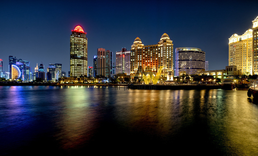 Nachtleben in Doha,Skyline bei Nacht,Lichterglanz der Stadt | Die abgebildete Skyline bei Nacht zeigt Doha, die Hauptstadt Katars. Doha liegt am Persischen Golf und ist bekannt für seine moderne, futuristische Skyline. Die Stadt ist ein aufstrebendes Reiseziel, das luxuriöse Erlebnisse und kulturelle Highlights bietet. Die Gebäude in der West Bay, dem Teil mit der beeindruckenden Skyline, wurden erst ab Ende der 1970er Jahre errichtet. Doha ist die am schnellsten wachsende Stadt Katars, in der der Großteil der Bevölkerung des Landes lebt.  - Realisiert mit Pictrs.com