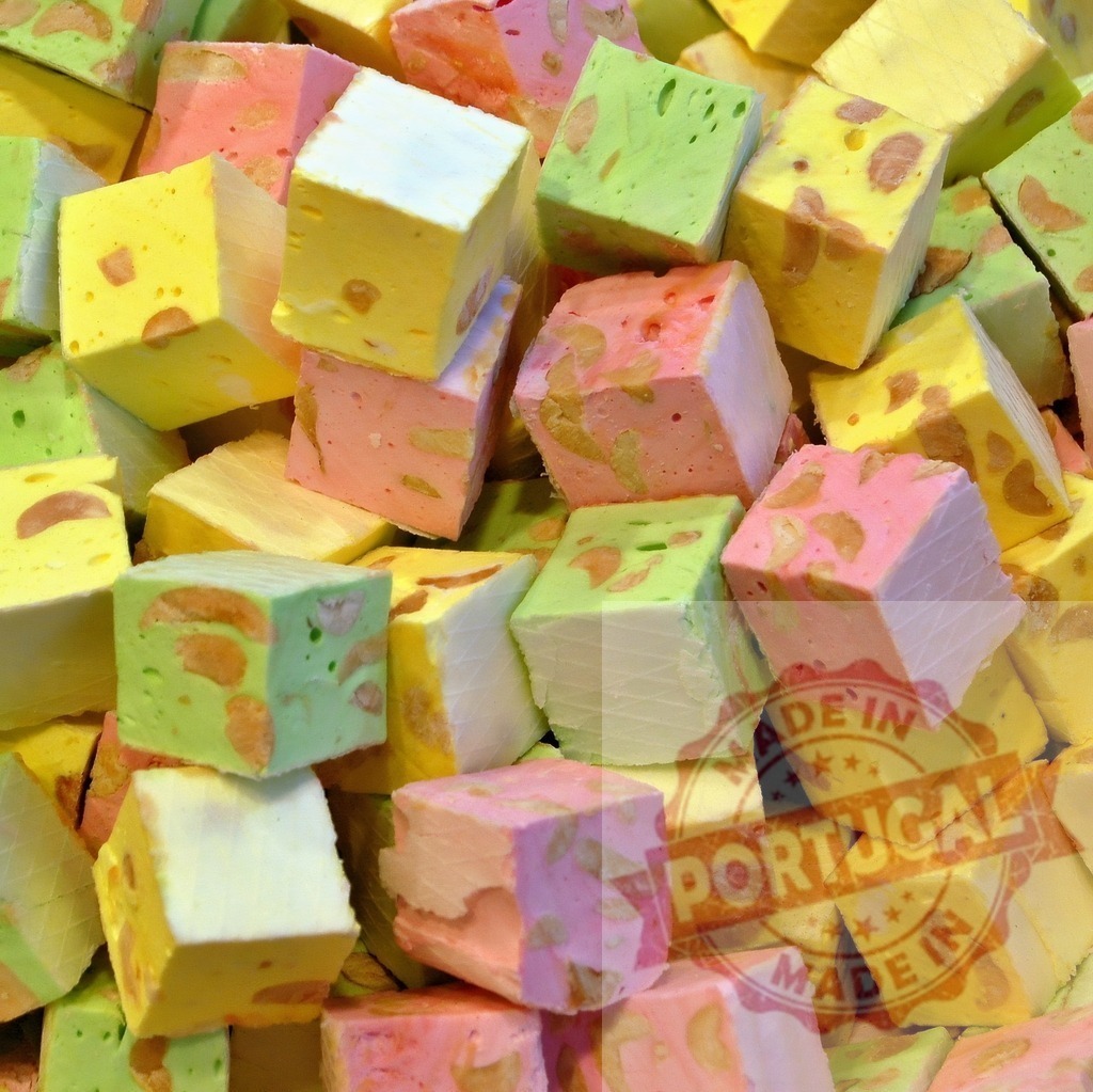 Colorful nougat candy cubes with nuts | Stacked nougat candy cubes in pastel colors, featuring nuts inside - Realized with Pictrs.com