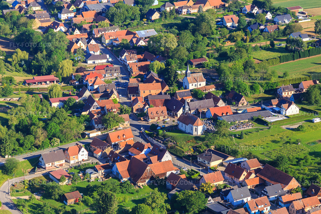 Aerial view: Two churches in the village center from the east in Wintzenbach in the state Bas-Rhin, France. – Photo: IMG_115036.jpg taken on 06/01/2019 by Werner Riehm/FLY-FOTO.com – Resolution of the original: 5472 x 3648 px