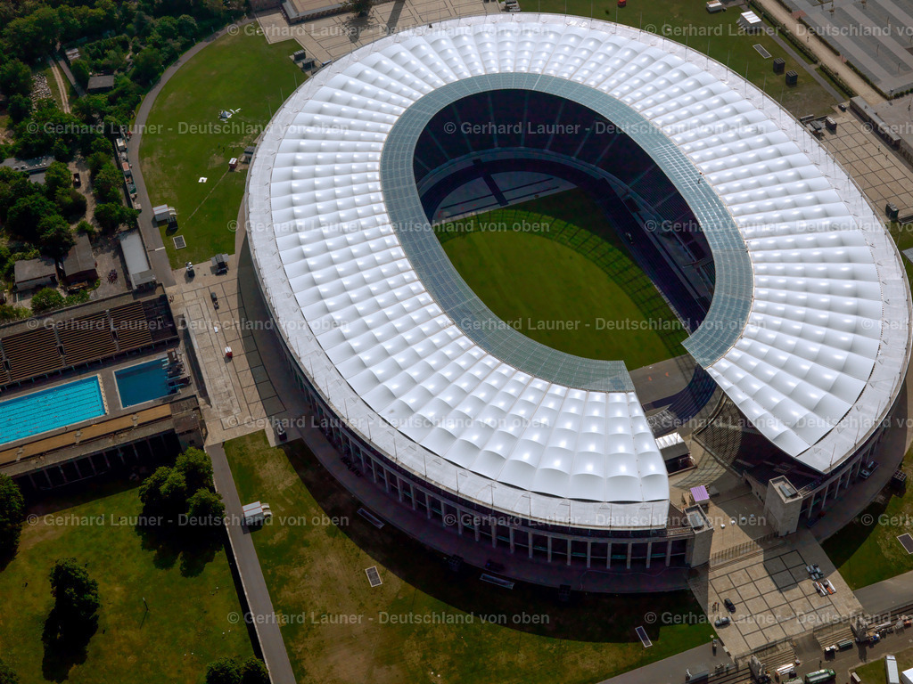 2790609 | Das Olympiastadion ist zentraler Bestandteil des axial aufgebauten Olympiageländes (ehemals: Reichssportfeld), zu dem auch das Sportforum, das Hockey-Olympiastadion, das Olympia-Reiterstadion, das Olympia-Schwimmstadion, die Waldbühne, das Maifeld, der Glockenturm und die Langemarckhalle, sowie die Stadion-Terrassen gehören. Die Ost-West-Achse erstreckt sich vom Olympischen Platz, wo sich der Haupteingang befindet, über das Stadion bis um Glockenturm. Das ebenfalls in ost-westlicher Richtung angelegte Stadionoval ist westlich durch eine Öffnung über dem Marathontor unterbrochen und eröffnet eine Sichtachse über das Maifeld zum Glockenturm.