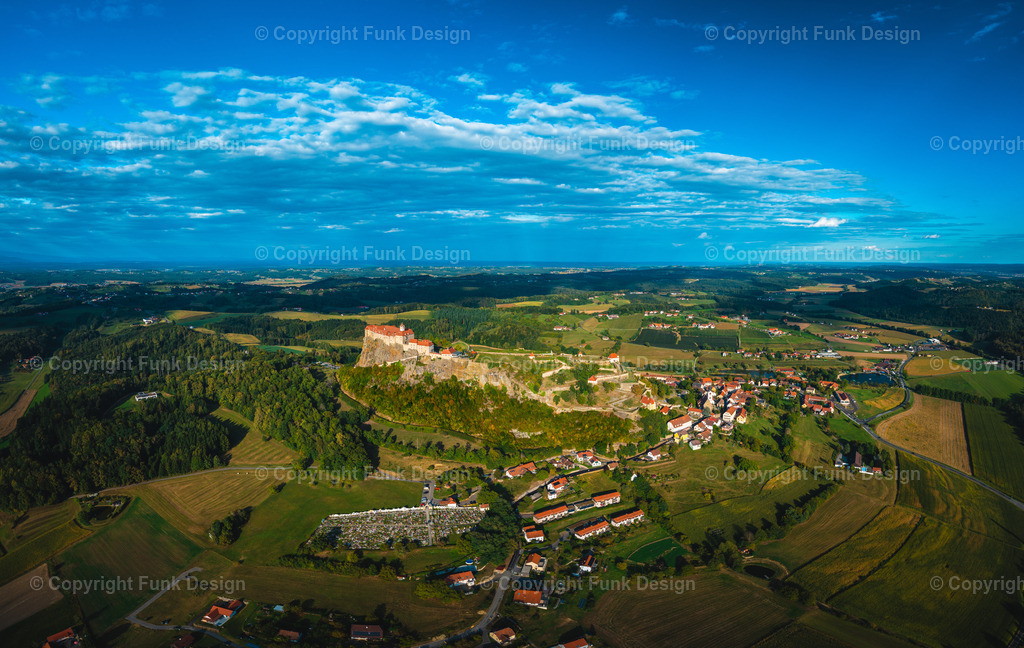 Drohnenpanorama der Riegersburg – Steiermark, Österreich | Die Riegersburg thront majestätisch auf ihrem markanten Felsen und blickt weit über das steirische Hügelland. Aus der Drohnenperspektive wirkt die Anlage besonders eindrucksvoll, eingerahmt von Feldern, Wäldern und einem dramatischen Himmel.