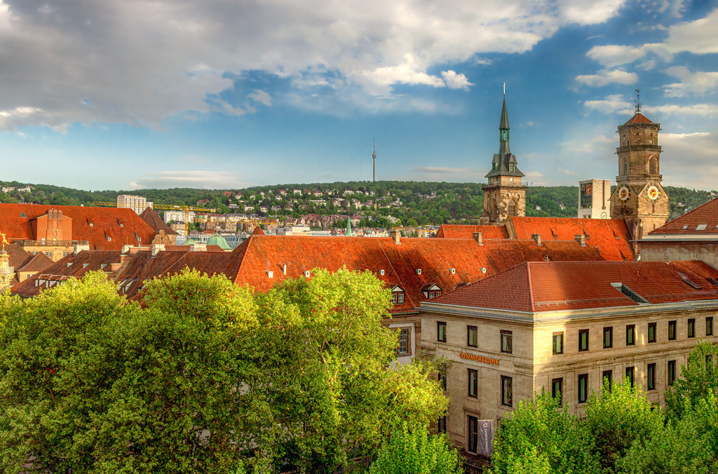 Blick über die Dächer der Stuttgarter Innenstadt,Stiftskirche | Das Bild zeigt den Blick über die Dächer der Stuttgarter Innenstadt mit den markanten Türmen der Stiftskirche und des Alten Schlosses im Hintergrund.Stiftskirche Stuttgart: Die evangelische Hauptkirche mit ihren ungleichen Türmen prägt die Silhouette der Stuttgarter Altstadt.Altes Schloss: Der Renaissancebau mit seinem Arkadenhof grenzt direkt an den Schillerplatz.Stuttgarter Kessel: Im Hintergrund sind die bewaldeten Hänge des Talkessels zu sehen. - Realisiert mit Pictrs.com