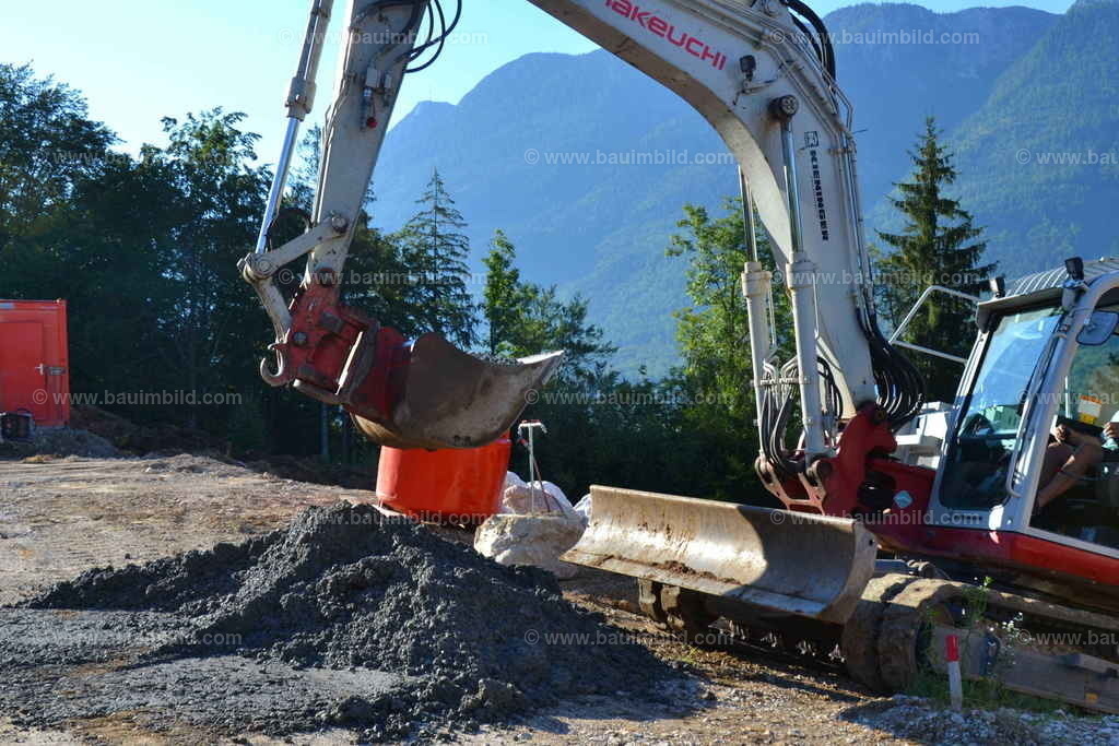 Magerbeton, Bagger | Auf Baustelle zwischengelagerter Magerbeton, daneben Raupenbagger für Beton-Zwischentransport 