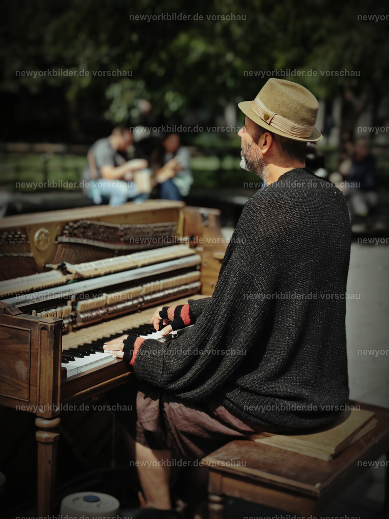 Washington Square Park – Musik, Kunst und pure Lebensfreude | Im Herzen von Manhattan liegt der Washington Square Park – ein Ort, an dem das Leben pulsiert. Hier treffen sich Menschen, um Musik, Kunst und die unverwechselbare Energie New Yorks zu genießen. An diesem Tag erfüllt ein Künstler den Park mit den Klängen von Coldplay, seine Stimme trägt die Melodie durch die Bögen und Wege, während die Sonne den Platz in warmes Licht taucht. Um ihn herum flanieren Menschen, lachen, tanzen und lassen sich von der Atmosphäre treiben. Der Park ist mehr als ein Treffpunkt – er ist ein Spiegel der Stadt: kreativ, lebendig und voller Geschichten. Dieses Motiv fängt die Magie des Augenblicks ein, die Verbindung von Musik und urbanem Leben, die New York so einzigartig macht. Ein Bild, das nicht nur einen Musiker zeigt, sondern die Seele einer Metropole, die niemals stillsteht und in jedem Ton ihre Freiheit spüren lässt.