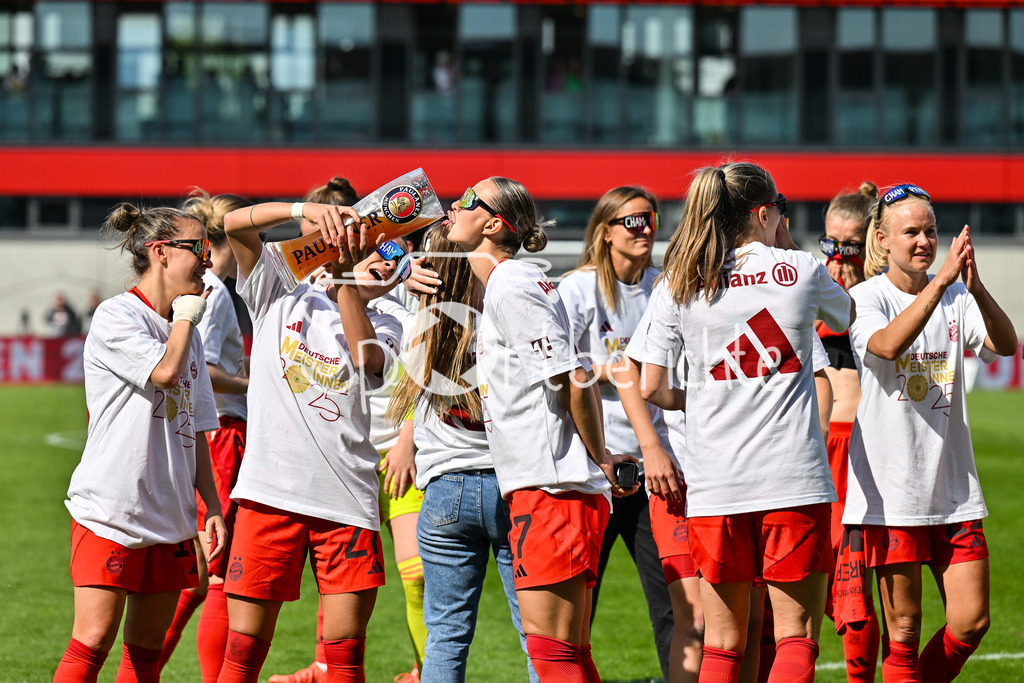 FC Bayern München - SC Freiburg | Die Spielerinnen des FC Bayern feiern die Meisterschaft nach dem Heimsieg gegen den SC Freiburg / Frauen Bundesliga: FC Bayern Muenchen - SC Freiburg, FC Bayern Campus am 27.04.2025 / Arianna CARUSO (FC Bayern Muenchen Frauen 27) gibt Klara BUEHL (FCB #17) einen Schluck auf dem Paulaner Bierkrug / Bierglas
