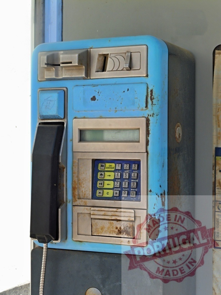 Old and rusty blue public phone showing signs of decay | Weathered and rusty blue public telephone booth showing keypad, receiver, and coin slot - Realisiert mit Pictrs.com