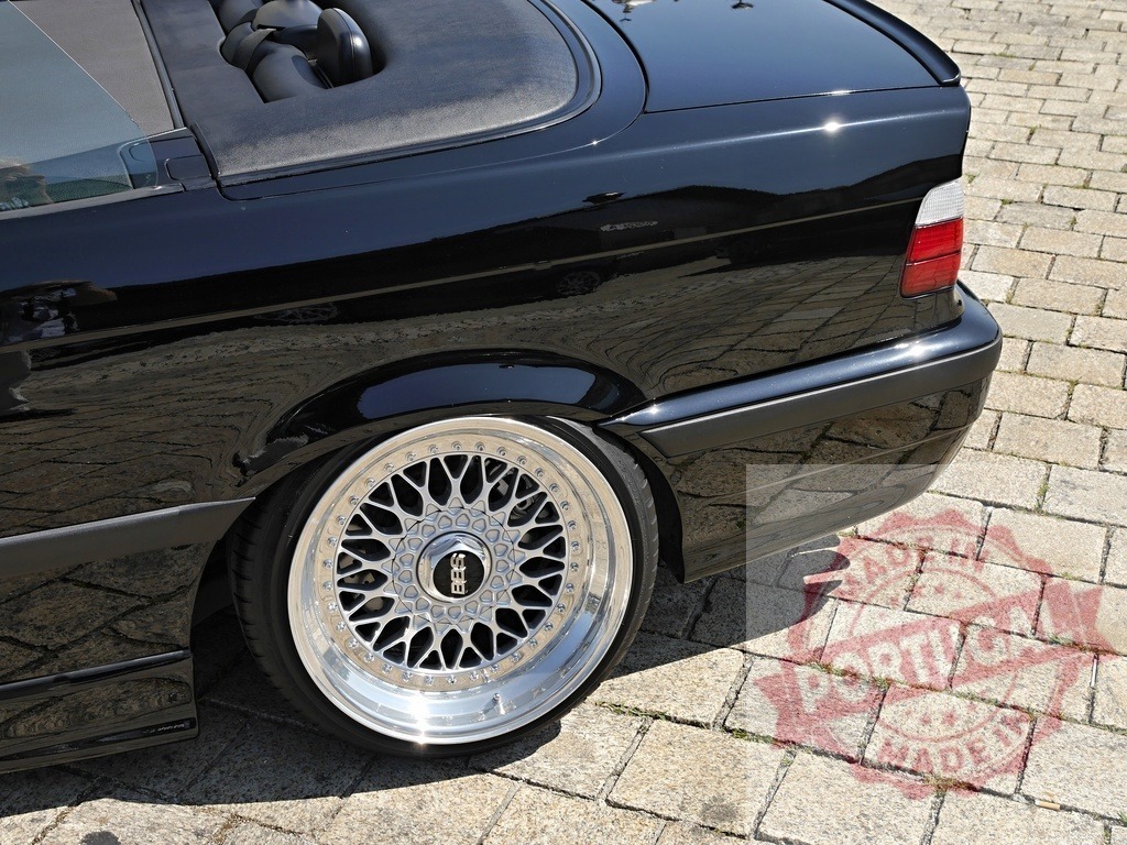 BMW E36 convertible with BBS wheels slammed | Black BMW E36 convertible displaying custom lowered stance and aftermarket BBS rims on a cobblestone street - Realized with Pictrs.com
