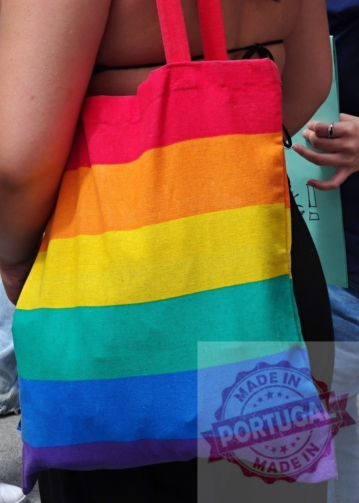 Person carrying rainbow flag tote bag at Pride event | Person walking with a colorful Pride flag tote bag, representing LGBTQ+ community and support - Realisiert mit Pictrs.com