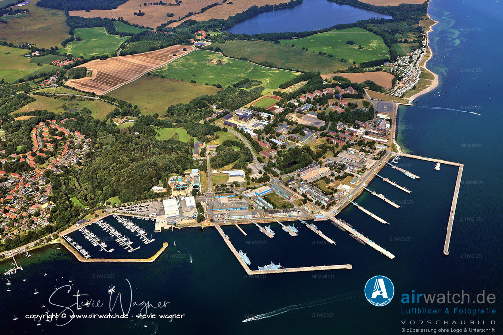Luftbild Eckernförde - Die strategische Bedeutung des Marine-Stützpunkts für die Ostsee ist enorm | Die strategische Bedeutung des Stützpunkts für die Ostsee ist enorm, da er die einzige Möglichkeit für große Schiffe und U-Boote bietet, sicher an- und abzulegen. In den letzten Jahren wurden erhebliche Investitionen in die Modernisierung und Sanierung des Standorts getätigt. So wurde im Jahr 2024 die Taucherübungshalle wieder in Betrieb genommen, nachdem sie mehrere Jahre saniert worden war, und die Hallenausbildung der Minentaucher und Kampfschwimmer ist wieder möglich.