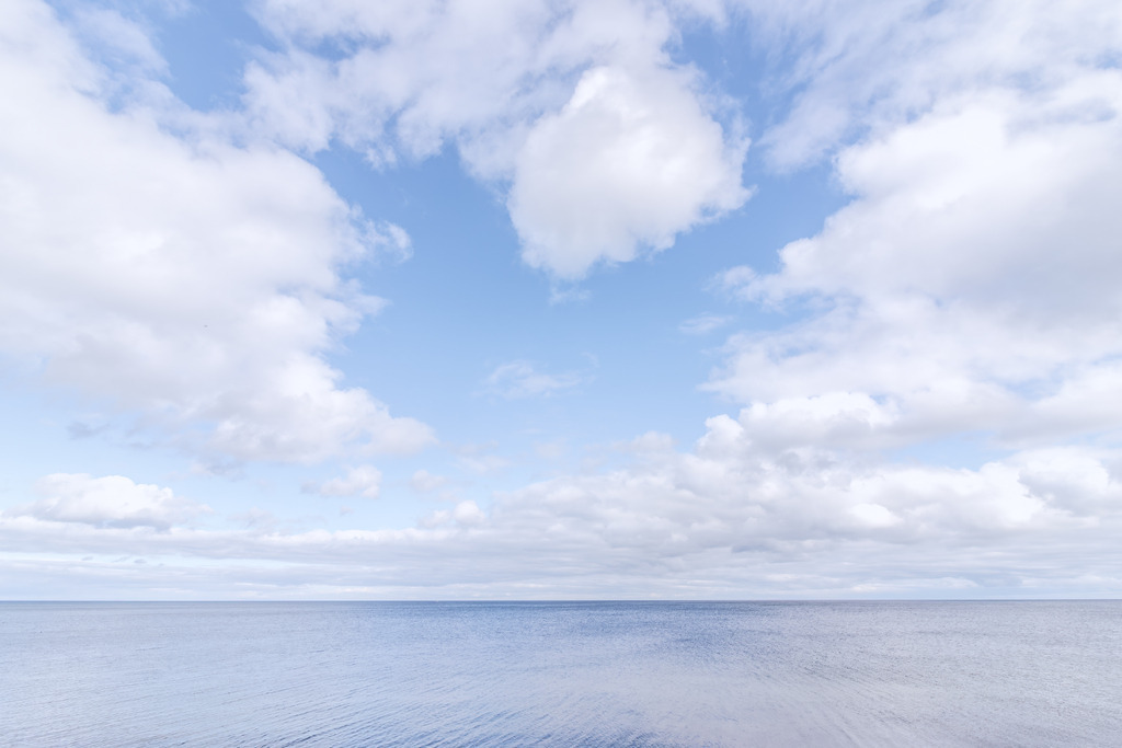 Akustikbild: Wolkenweite über ruhigem Meer – Minimalistische Ostseeklarheit | Dieses Wandbild zeigt die weite Ruhe von Himmel und Meer, geprägt von großen, sanften Wolken und einer klaren Horizontlinie. Die minimalistische Bildsprache wirkt modern, offen und zeitlos und fügt sich ideal in natürliche, klare Einrichtungsstile ein. Als Akustikbild verbessert es die Raumakustik, reduziert störenden Nachhall und sorgt für eine angenehm gedämpfte Klangumgebung.