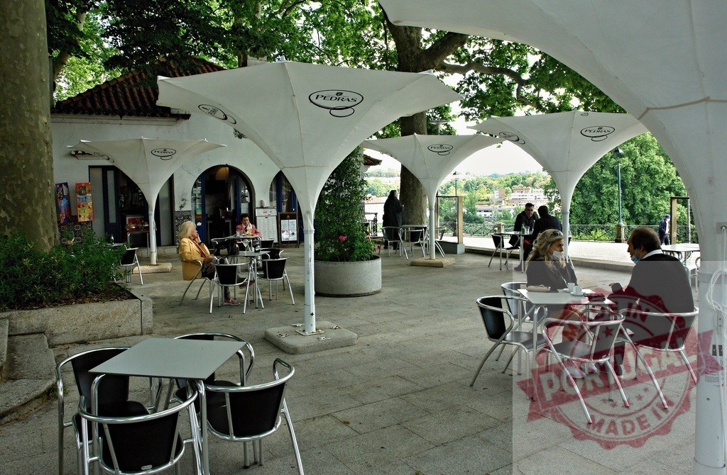 People enjoying a summer day at outdoor cafe. Portugal - Norte | People sitting at tables under white umbrellas at an open-air cafe terrace - Realisiert mit Pictrs.com