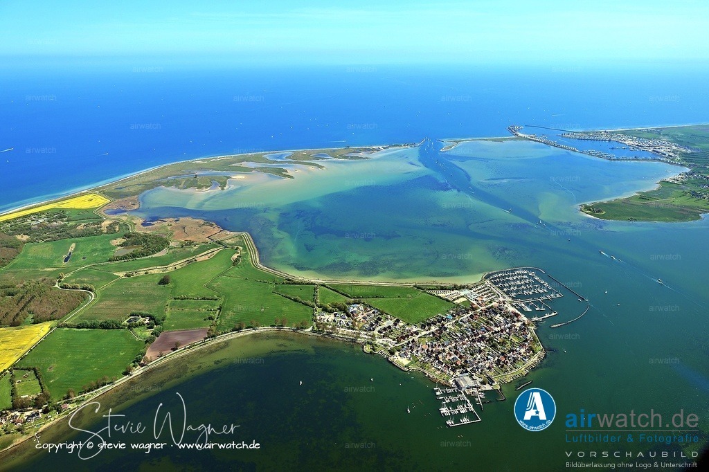  Luftbild OstseeResort Olpenitz - Exklusive Ferienhäuser an der Ostseeküste | Maasholm: Der Ort entstand ursprünglich als Insel und ist heute über einen Damm erreichbar. Maasholm war historisch ein Seefahrer- und Fischerdorf, das sich nach dem Übergang von Dänemark zu Preußen 1864 zunehmend auf die Fischerei spezialisierte. Heute prägen Fischerei, Tourismus und der Sportboothafen das Leben im Ort. Maasholm besitzt einen bedeutenden Fischereihafen