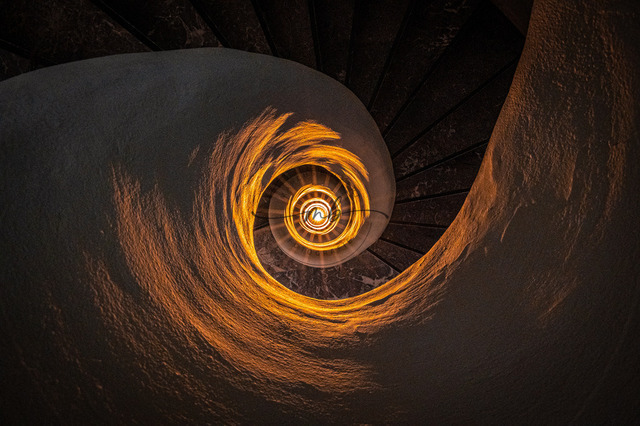 Treppe eines Treppenhauses mit Scheinwerfer | Die Treppe eines Treppenhauses mit Scheinwerfer in der Mitte dreht sich wie ein Schneckenhaus - Realisiert mit Pictrs.com