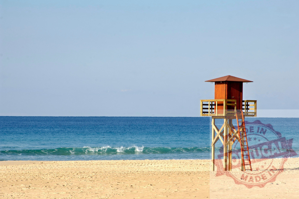 Lifeguard tower standing on sandy beach in summer. Espana - Cadiz | Lifeguard tower standing on an empty beach with ocean waves and clear sky - Realized with Pictrs.com