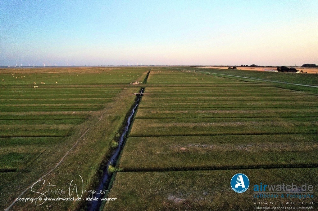 Nordsee, Nordfriesland, Nordstrand, Pohnshalligkoog - airwatch.de | Der Pohnshalligkoog ist der jüngste bewohnte Koog der Halbinsel Nordstrand in Schleswig-Holstein. Er ist als Ortsteil der Gemeinde Nordstrand angehörig. Die Pohnshallig, eine ehemalige Hallig, wurde durch die Burchardiflut im Jahre 1634 von der Insel Alt-Nordstrand abgerissen. Im 18. und 19. Jahrhundert wurden sukzessive ehemalig besiedelte Landstriche neu bedeicht und die Insel Stück für Stück neu in Richtung Osten ausdehnte. Im Jahr 1924 erfolgte die Eindeichung der Pohnshallig, nachdem die unbewohnte Hallig zeitweise durch die Schobüller zur Heugewinnung genutzt worden war.Größe und LageDer Pohnshalligkoog umfasst eine Fläche von etwa 695 Hektar und ist der östlichste und zweitgrößte Koog der Halbinsel Nordstrand. Die Eindeichung des Pohnshalligkoogs war 1924 abgeschlossen. Trotz der Schwierigkeiten bei der Errichtung des Deiches und des verschlammten Bodens konnten die ersten Pächter 1924 den Koog übernehmen. Fünf Jahre nach der Eindeichung wurden die Pachtverträge jedoch aufgelöst und das gesamte Land der “Gemeinnützigen Siedlungsgesellschaft Deutscher Osten” übergeben.