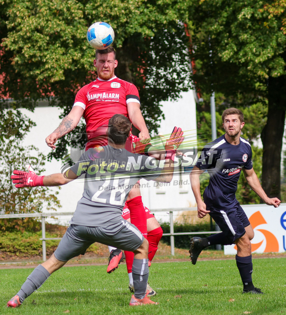 Bünder SV - VfL Holsen | Auf dem Bild zu sehen: rot Bünder SV: Fabian Schnelle ; blau VfL Holsen v.l.: Leon Quirin (TW), Roman Adler  Bünder SV, VfL Holsen, Saison 26/27, Kreisliga A, Bünde, Deutschland - Realisiert mit Pictrs.com