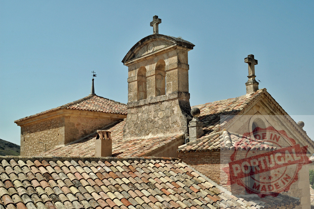 Church bell tower roof tiles under blue sky. Cuenca - Spain | Old stone church with tile roofs, bell tower and crosses, representing religion and tradition - Realisiert mit Pictrs.com