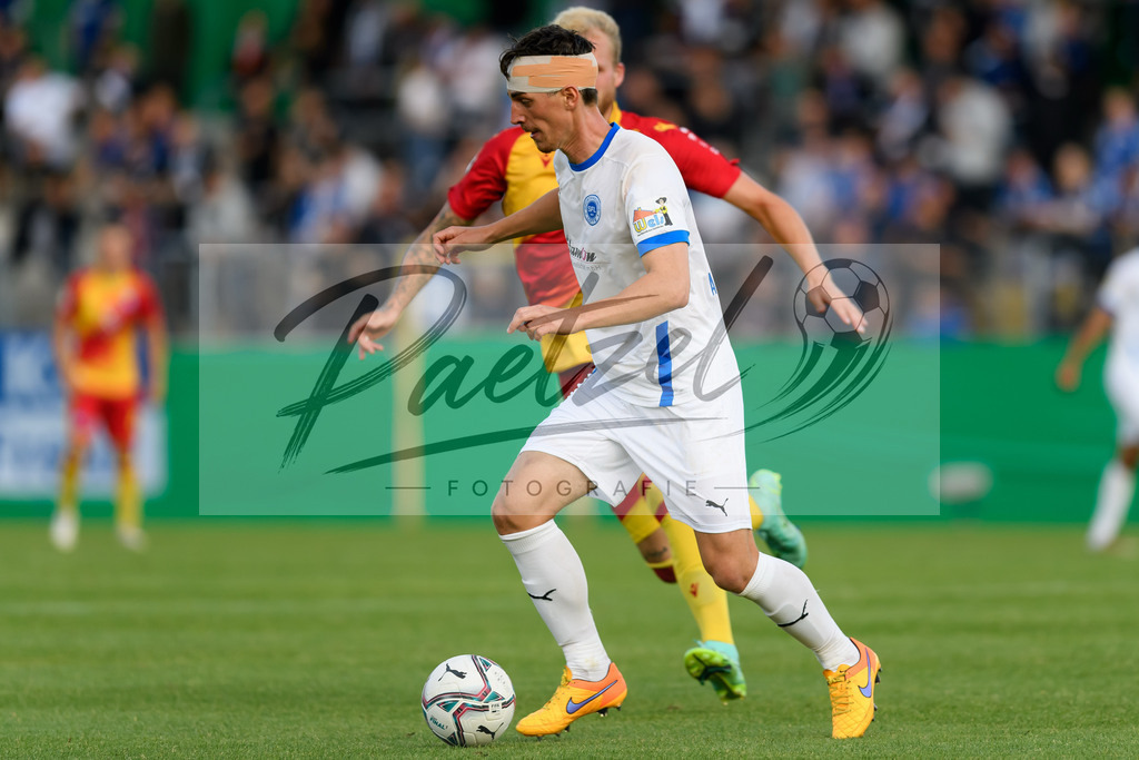 LOTKSC20210809_182 | Fussball, Herren: Luis Allmeroth (Sportfreunde Lotte) in Aktion, am Ball, Einzelaktion beim Spiel der 1. Runde im DFB-Pokal zwischen SF Lotte und Karlsruher SC im Stadion am Lotter Kreuz am 09.08.2021 in Lotte, Deutschland.DFB / DFL REGULATIONS PROHIBIT ANY USE OF PHOTOGRAPHS AS IMAGE SEQUENCES AND/OR QUASI-VIDEO. - Realisiert mit Pictrs.com